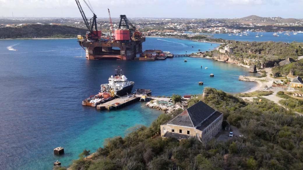 View of Curacao's Caracasbaai with quarantine building, Tugboat Beach, oil rig, Fort Beekenburg and Spanish Water in the background