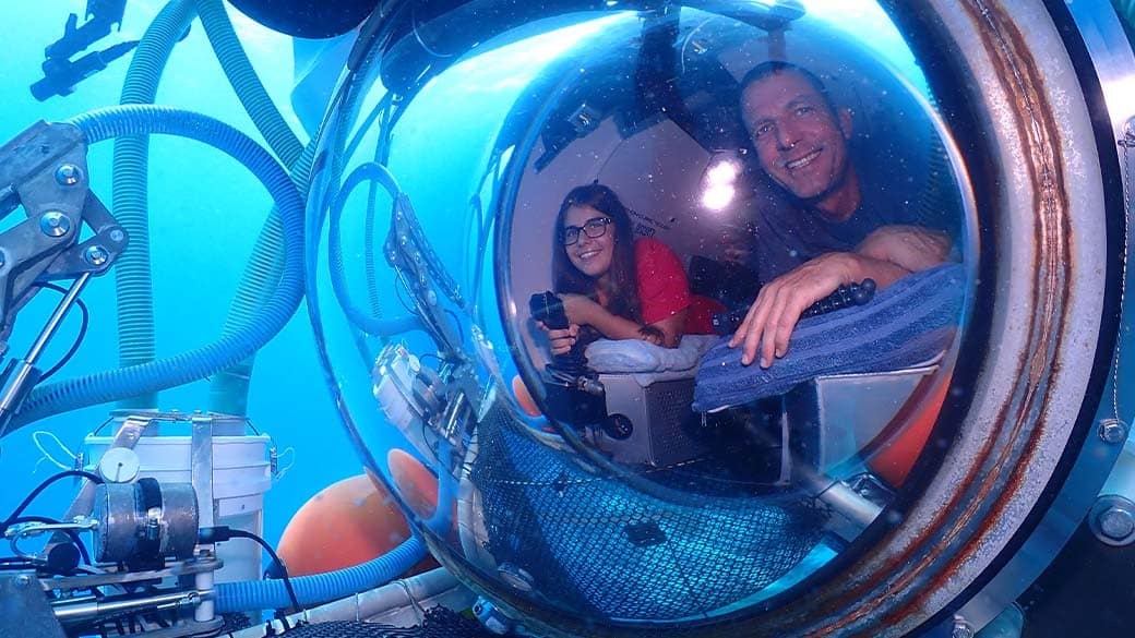 Paula and Stefan look out of the huge porthole of the Substation Curacao submarine