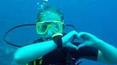 Emily macht beim Scuba Diving ein Herz unter Wasser