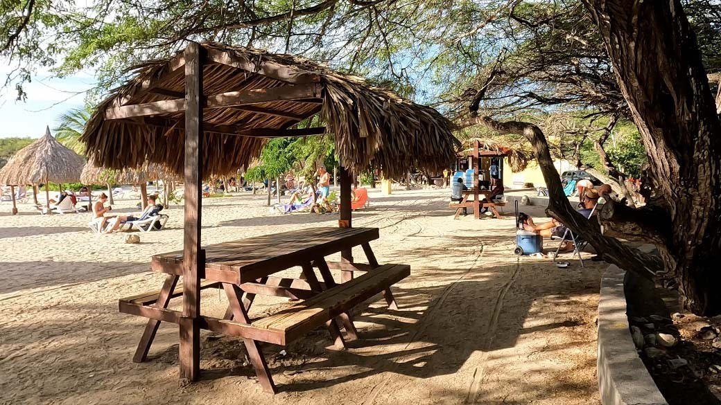 Palapa on Daaibooibaai Beach: a covered wooden seating set with palm leaves on top