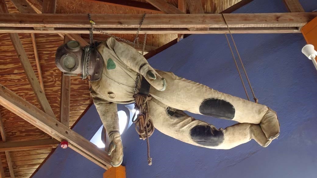 Dekoration an der Holzdecke des Kokomo Restaurants: ein uralter Ganzkörper Taucheranzug mit Metallhaube