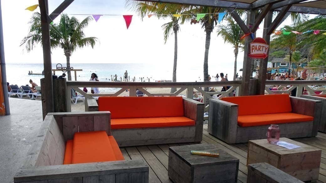 Loungemöbel mit orangen Polstern auf der Terrasse des Kokomo Restaurants - reserviert für eine private Party